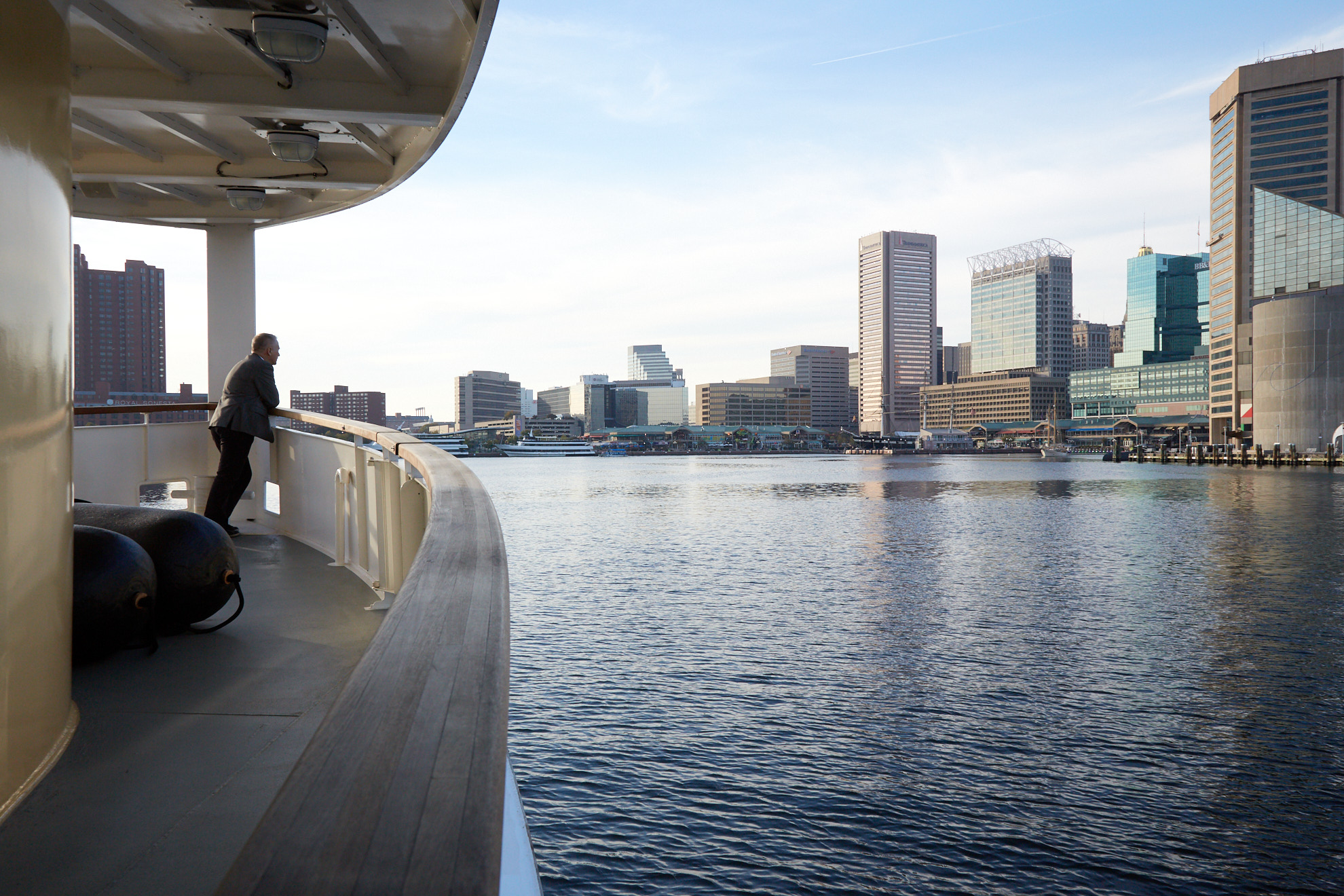 A man gazes into a harbor from a boat. Photo by Baltimore Lifestyle Photographer Tracey Brown of Papercamera