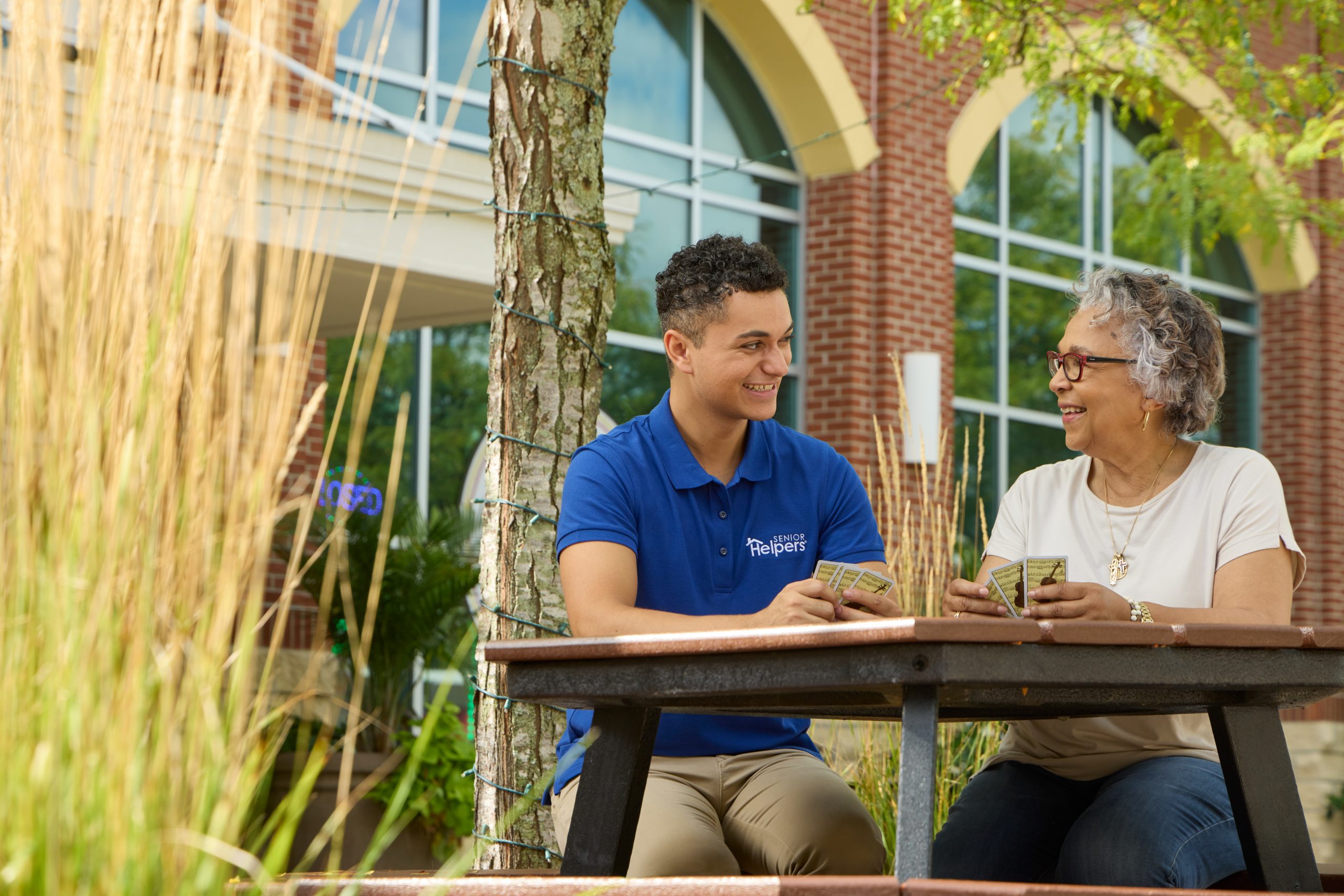 A companion plays cards with a senior. Images by Lifestyle Photographer Tracey Brown