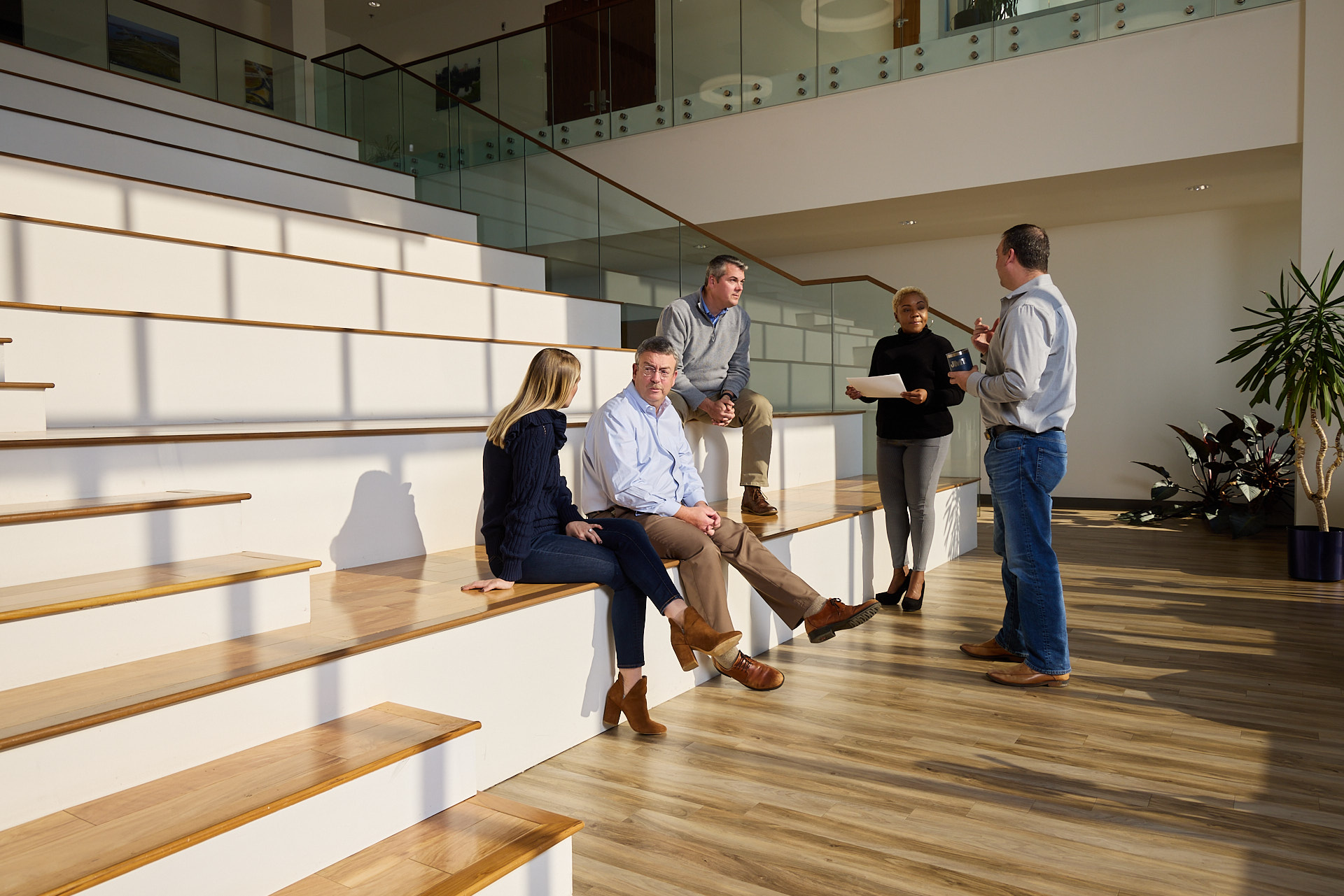 A group of business people meeting in a lobby. Photo by Baltimore commercial photographer Tracey Brown of Papercamera